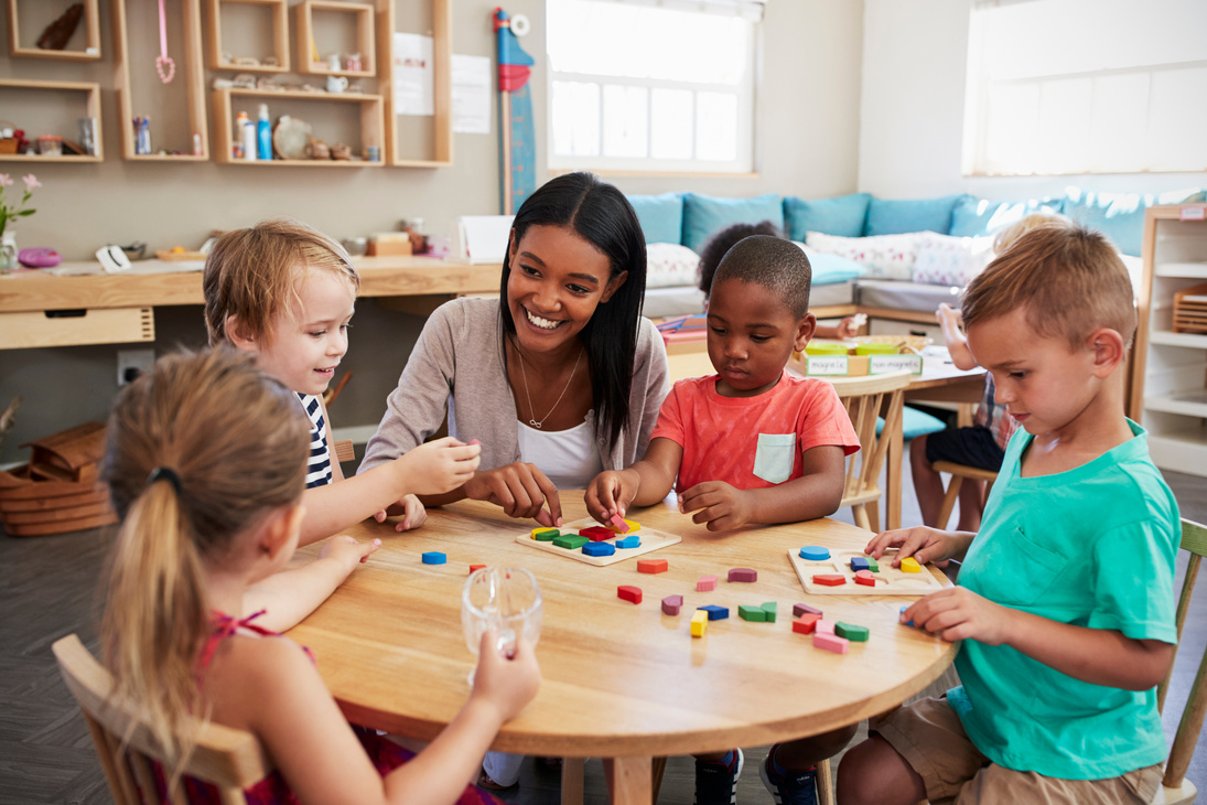 Teacher and Pupils Using Wooden Shapes in Montessori School